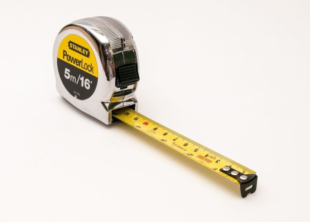 A close-up photograph of a Stanley PowerLock 5m/16ft measuring tape on a white background.
